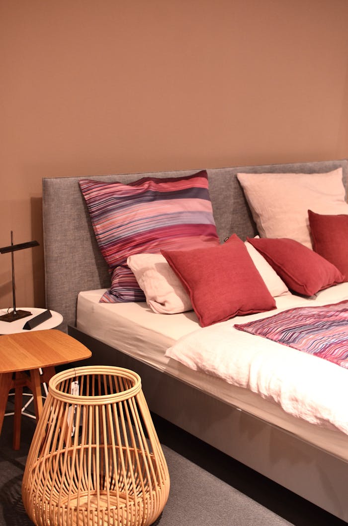 about-img-01 Stylish bedroom scene with colorful pillows, a rattan basket, and modern decor for a cozy interior.